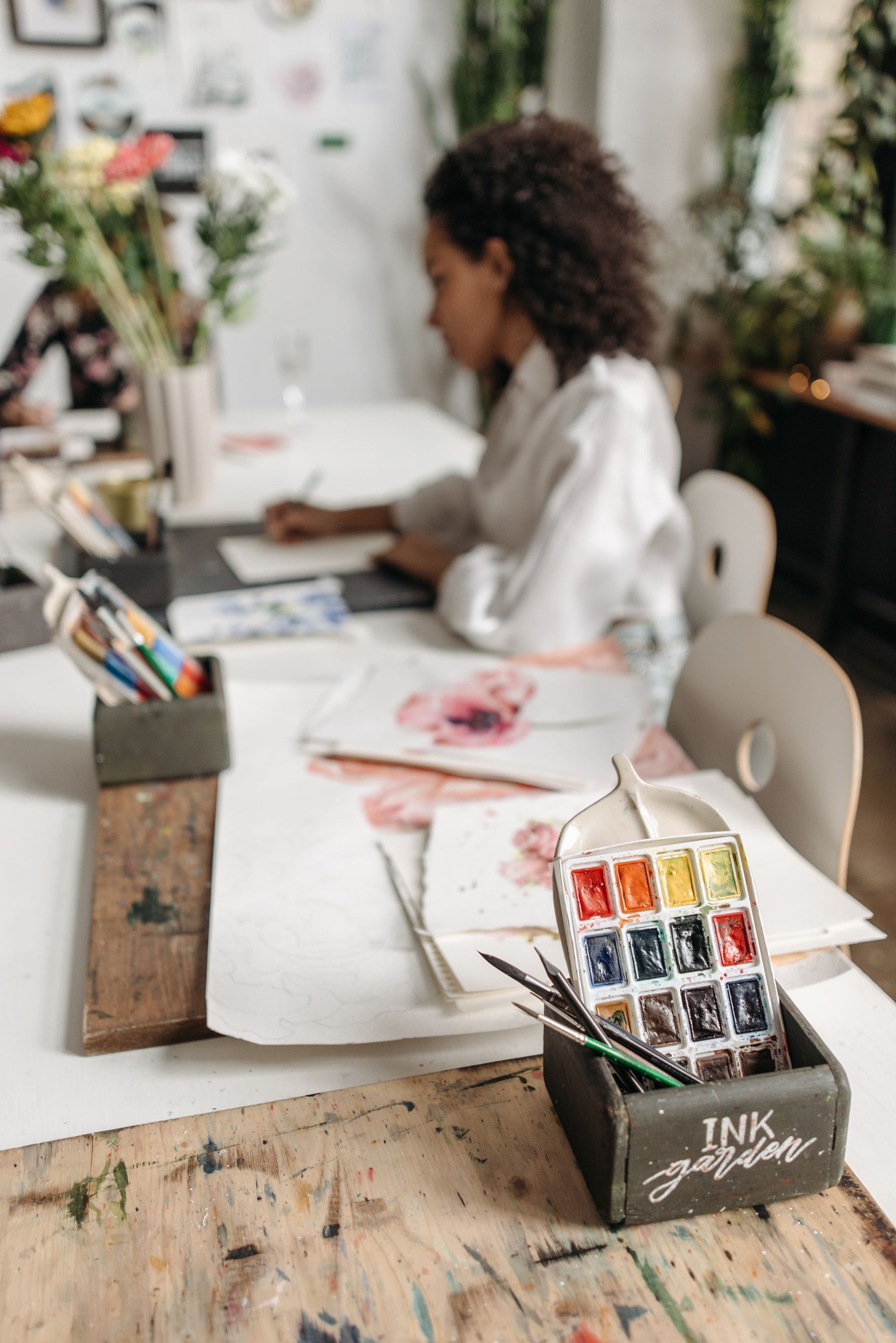 Artist working with watercolour materials in a real studio